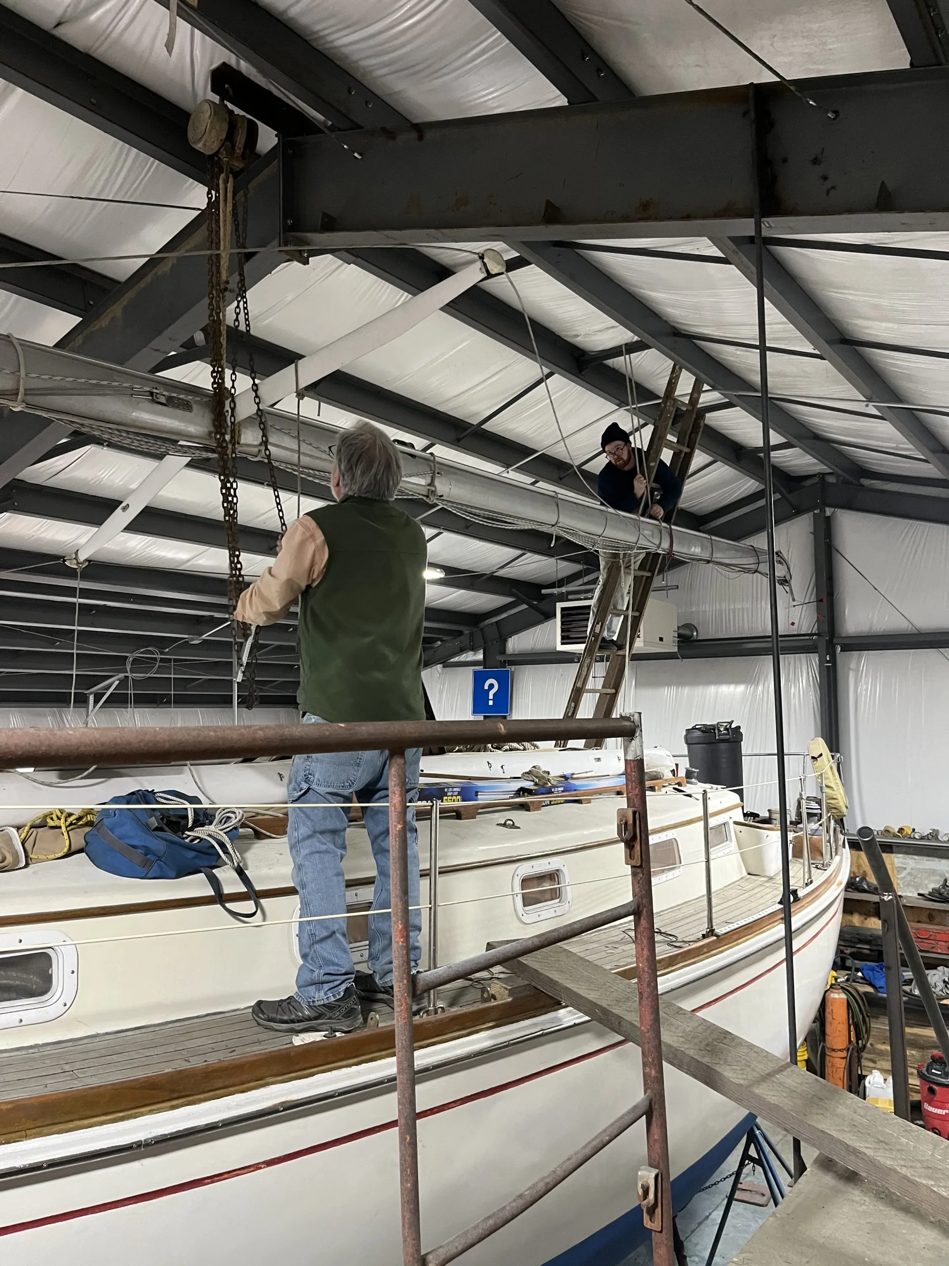 people raising sailboat mast