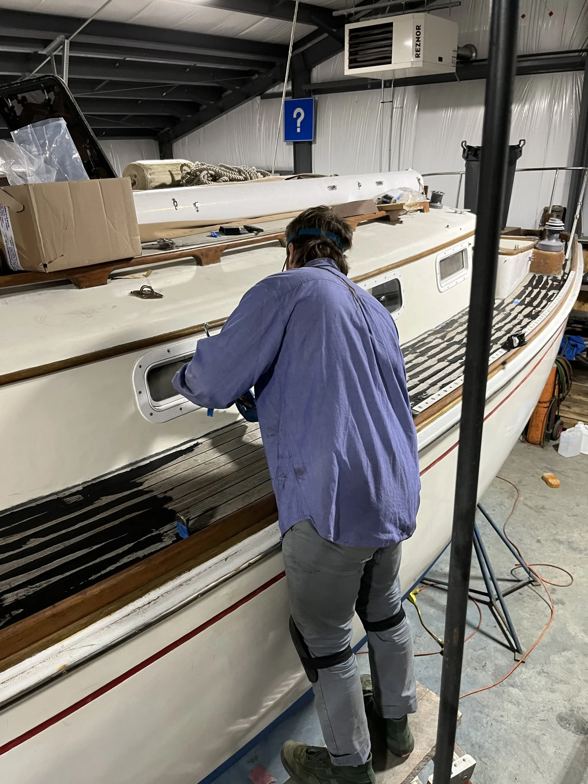 person caulking sailboat deck