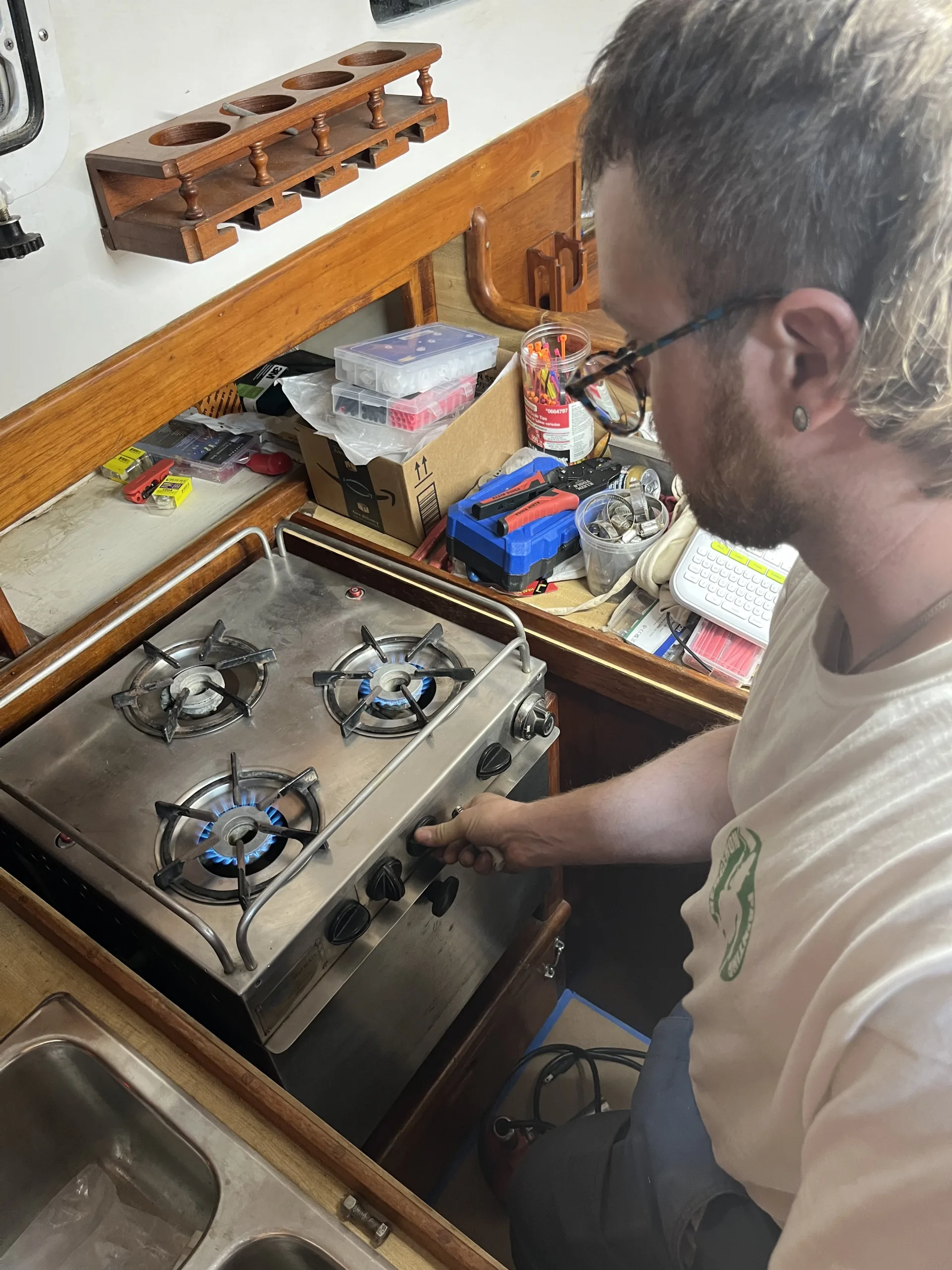 person turning on oven in boat cabin